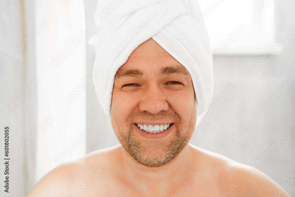 A man wipes himself with a towel after a shower and makes a turban on his head. textiles for the bathroom. daily hygiene and body care. A man wipes himself with a towel after a shower and makes a turban on his head. textiles for the bathroom. daily hygiene and body care.
