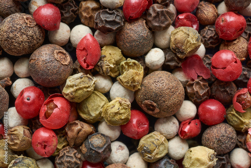 Different types of peppercorns, different colors and shapes close-up.