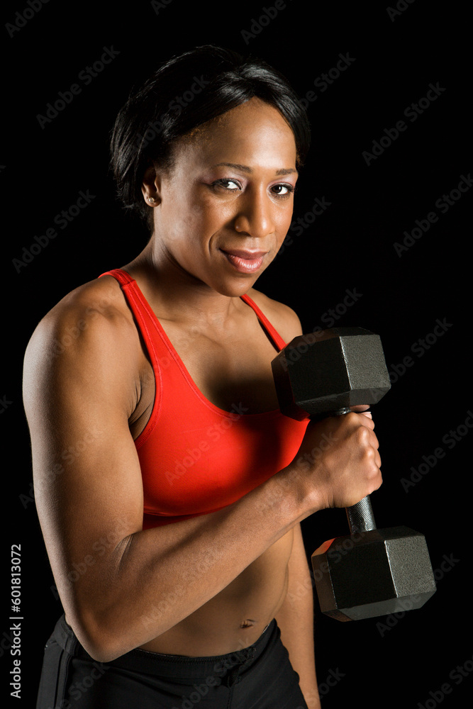 African American young adult woman holding dumbbell and looking at viewer. African American young adult woman holding dumbbell and looking at viewer.