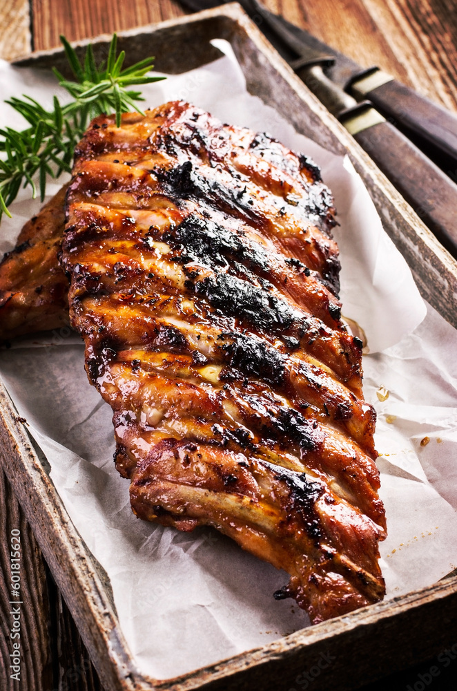 Barbecue veal spare ribs with hot honey chili marinade served as close-up on a design stone tray