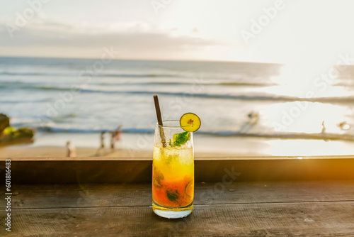 Photo of fresh orange juice on sunny day on the beach, sunset on Bali
