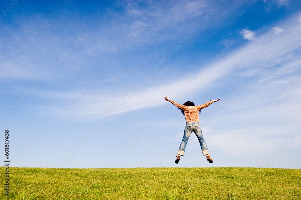 Woman jumping on green field