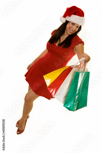 Full body of a Hispanic woman in red dress and santa hat holding colorful packages over white