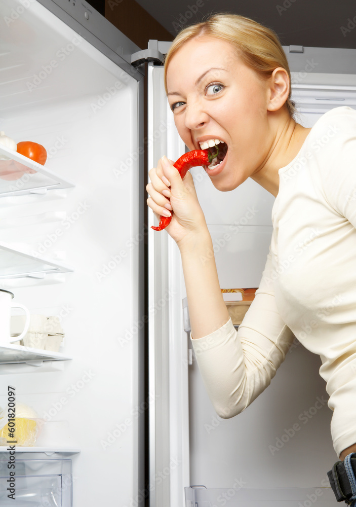 A hungry woman is peeping into an empty fridge A hungry woman is peeping into an empty fridge