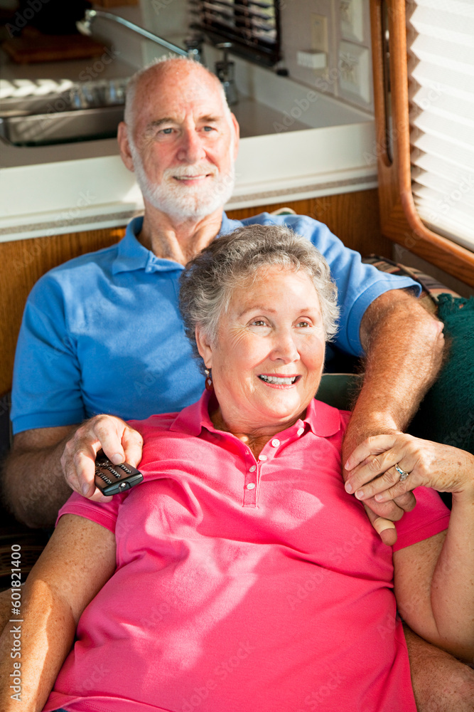 Retired senior couple watching television in their motor home. Retired senior couple watching television in their motor home.