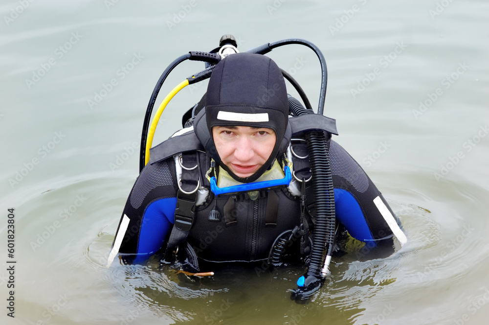 Obraz premium Scuba diver in wet suit entering the cold water