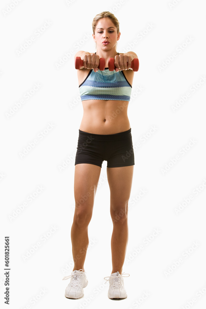 Full body of an attractive blond woman in great physical shape wearing black shorts and workout top standing on white with arms out holding three pound weights Full body of an attractive blond woman in great physical shape wearing black shorts and workout top standing on white with arms out holding three pound weights
