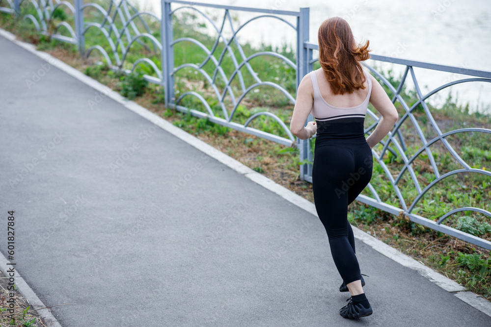 a red-haired girl running along the sidewalk along the river on a summer evening, a running away girl a red-haired girl running along the sidewalk along the river on a summer evening, a running away girl