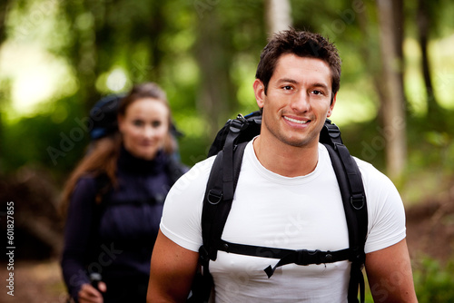 A portrait of a male hiking in the forest with a female