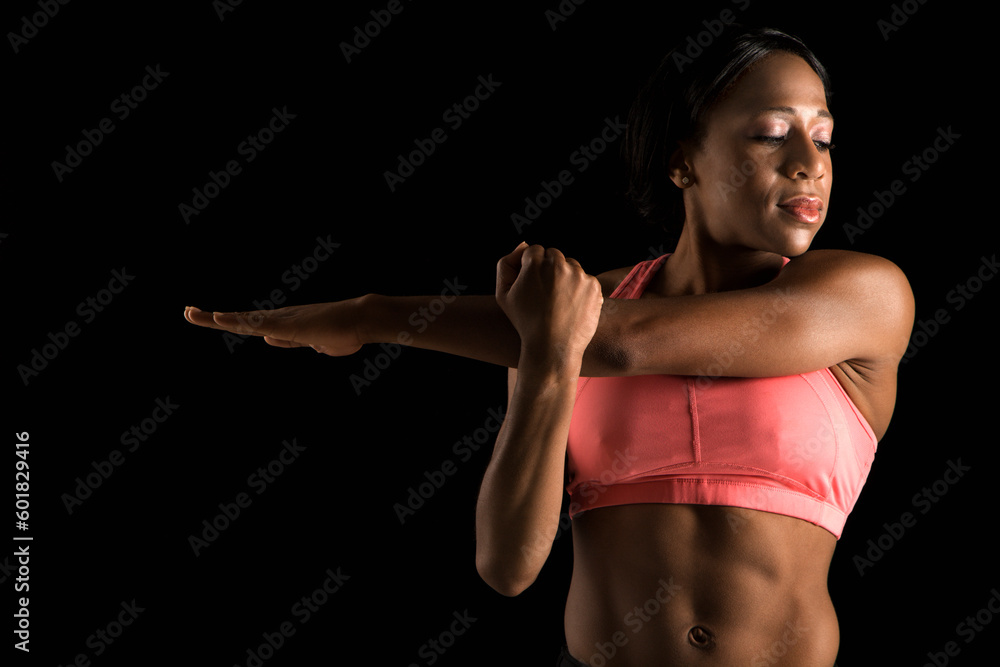 African American young adult woman in sports bra stretching arms with eyes closed. African American young adult woman in sports bra stretching arms with eyes closed.
