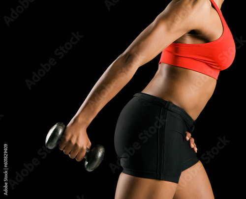Side view if torso of African American young adult woman holding dumbbell outstretched. © Designpics