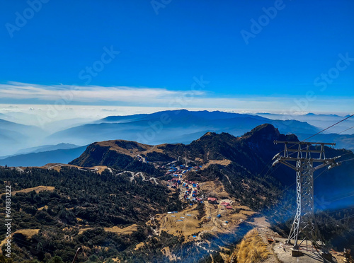 Принти на полотні View of the beautiful Kuri village of Kalinchowk, Nepal from the top of a mountain with the clouds and mountains in the distant