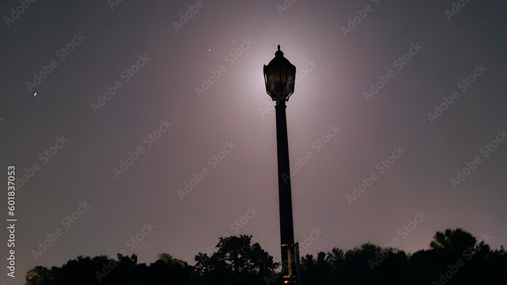 street lamp in front of moon