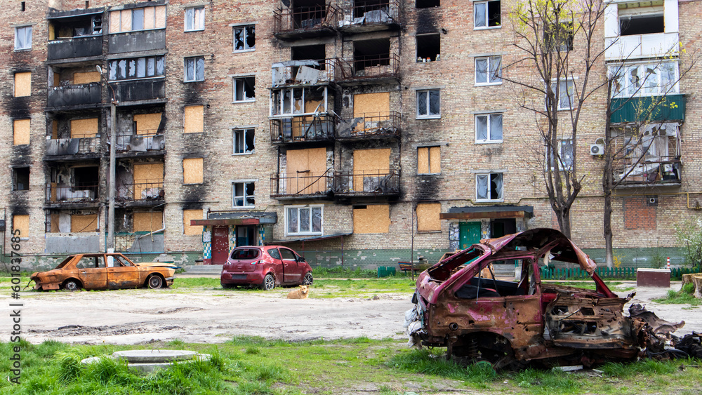 A broken Ukrainian civilian car, shot by artillery, stands in the courtyard of a destroyed house. War between Russia and Ukraine. The wreckage of an abandoned car.