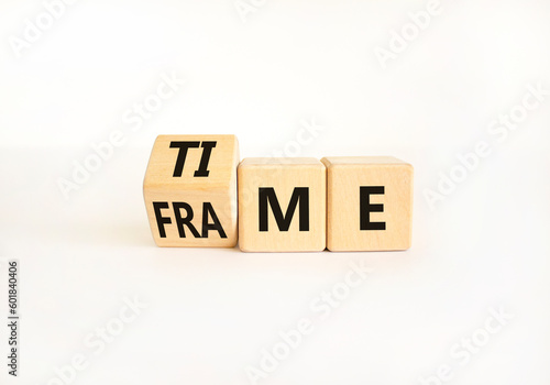 Time frame symbol. Businessman turns wooden cubes and change the concept word time to frame. Beautiful white table white background, copy space. Business and time frame concept.