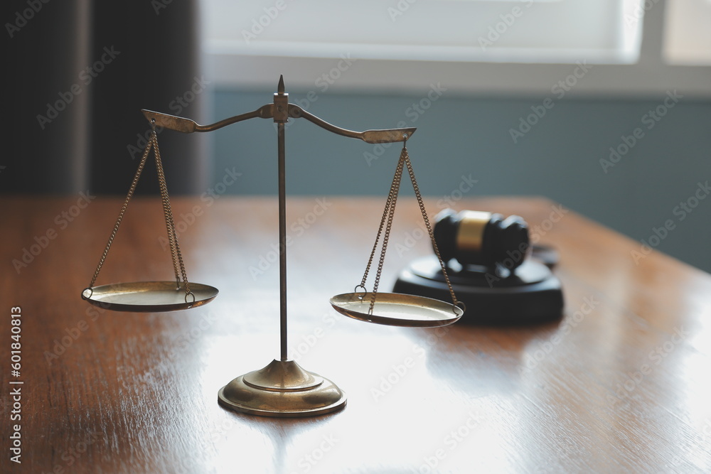 Business and lawyers discussing contract papers with brass scale on desk in office. Law, legal services, advice, justice and law concept picture with film grain effect Business and lawyers discussing contract papers with brass scale on desk in office. Law, legal services, advice, justice and law concept picture with film grain effect