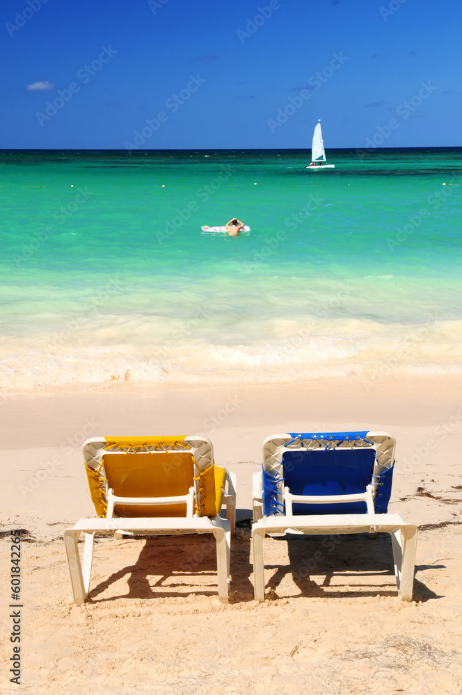 Two vacation chairs on sandy tropical beach of Caribbean island Two vacation chairs on sandy tropical beach of Caribbean island