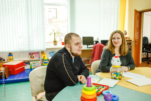 an autistic adult is engaged in class with a teacher
