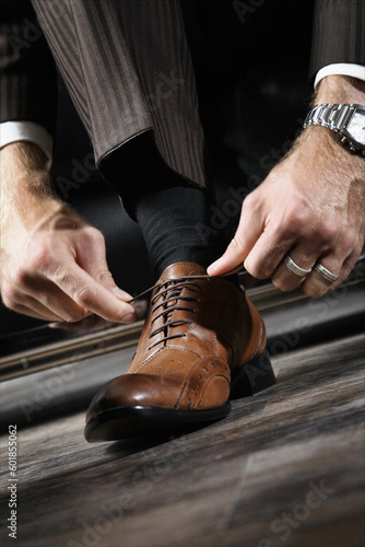 A businessman is lacing his shoes