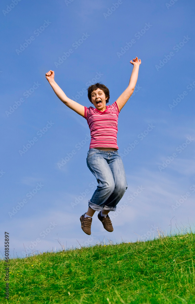 Young happy woman jumping high against blue sky Young happy woman jumping high against blue sky