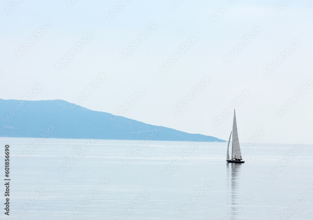 Vast open water surface with a small sailing boat