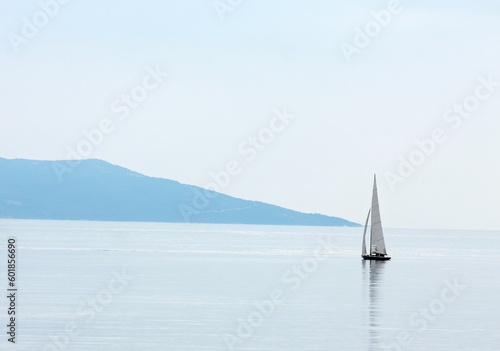 Vast open water surface with a small sailing boat © Designpics