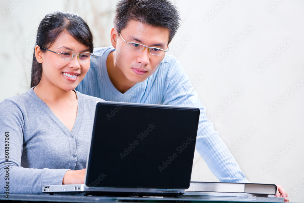 Obraz premium Young Asian couple browsing internet at home