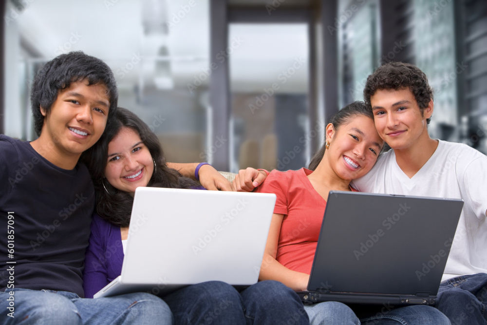 Two couples using laptops and smiling to camera at home Two couples using laptops and smiling to camera at home