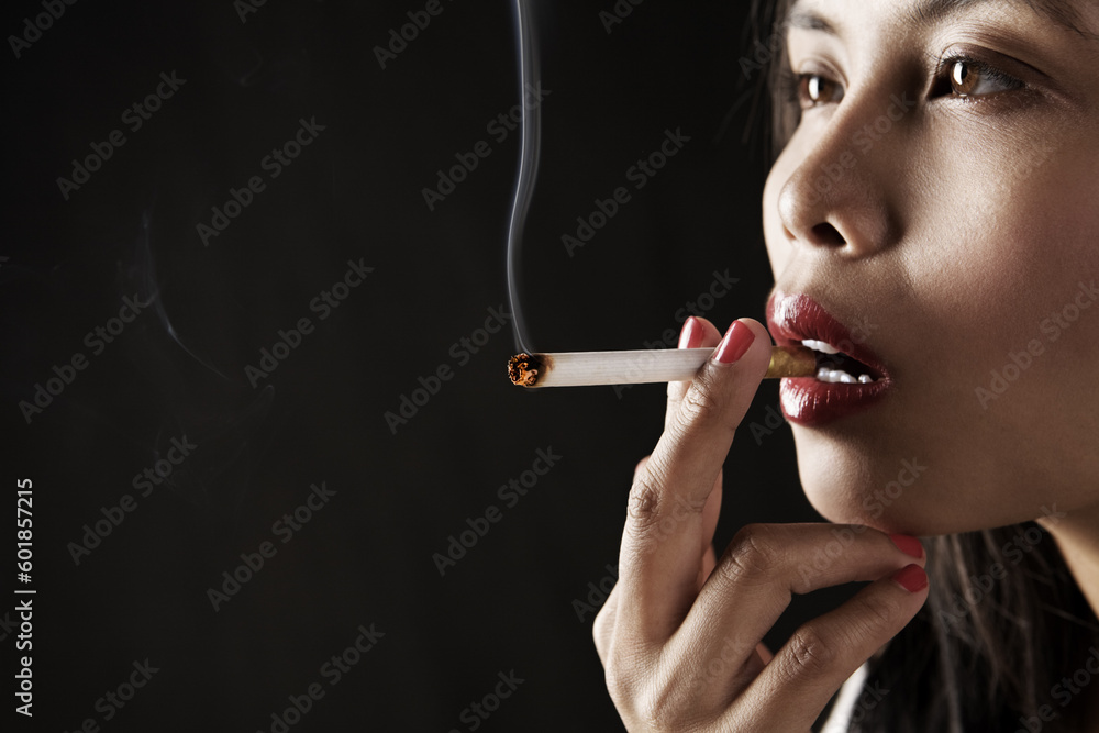 Obraz premium Woman smoking on dark area