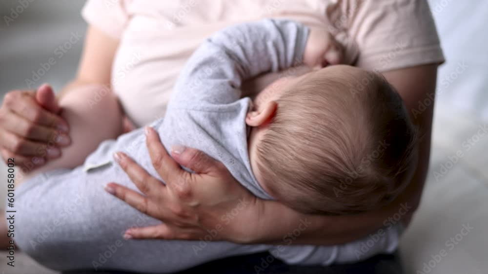 mother breastfeeding baby infant sitting on bed in bedroom.toddler eating breast milk closing