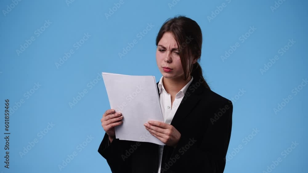 4k video of one girl thinking about something with papers on blue background. 4k video of one girl thinking about something with papers on blue background.