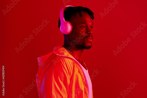 Headphones, fashion and black man profile with music and online song streaming. Internet radio, web audio and African male model with red background in a studio with gen z style and neon lighting