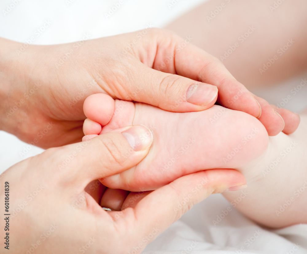 Mother massaging her child's foot, shallow focus Mother massaging her child's foot, shallow focus