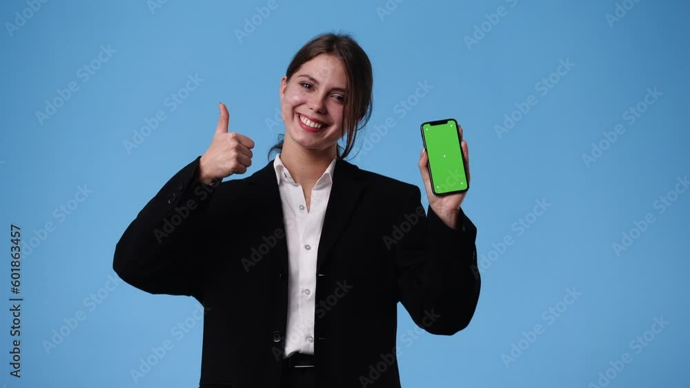 4k video of one girl using chroma key phone and showing thumbs up over blue background. 4k video of one girl using chroma key phone and showing thumbs up over blue background.