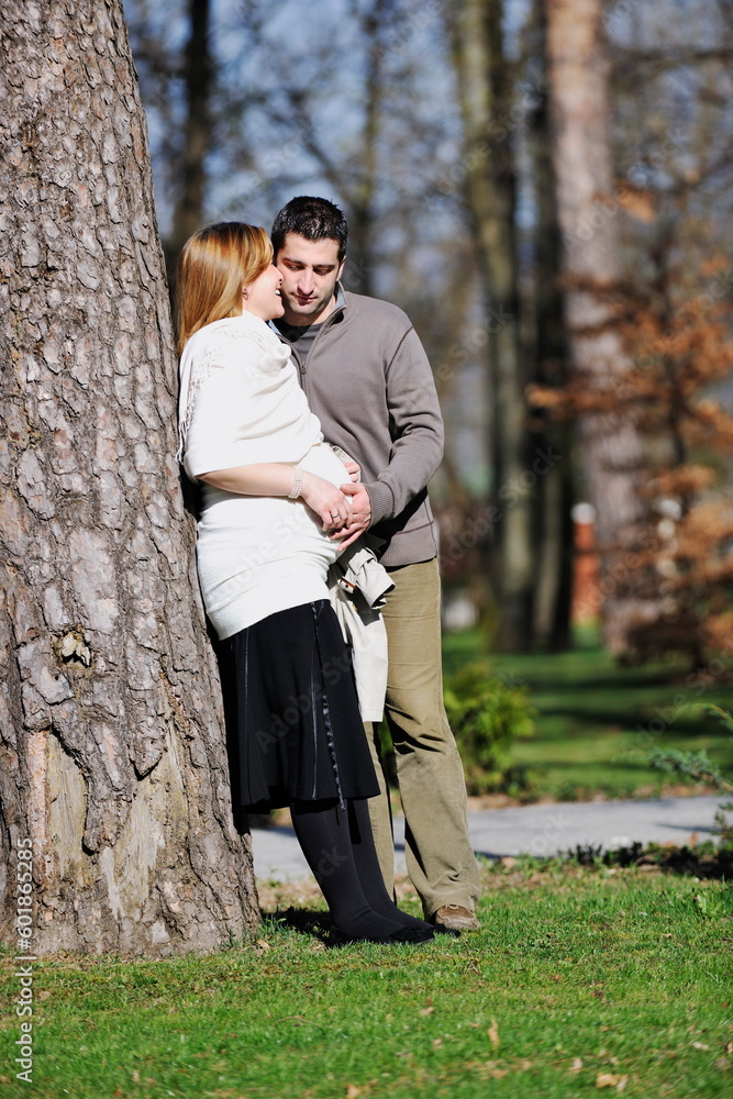 Fototapeta premium happy young married family couple outdoor in nature have fun and waiting baby and representing young family growth and pregnancy concept