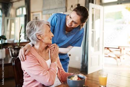 Healthcare, elderly woman with nurse with breakfast at her home and at the table in living room. Support or communication, caregiver and conversation with medical person with senior or old female. photo