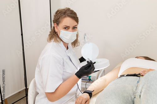 Cosmetologist Doing Hair Removal Procedure With Electrolysis On Hand Of White Young Patient  Electroepilation In Beauty Salon. Horizontal Plane. Authentic High quality photo.