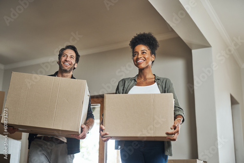 Happy couple, real estate and boxes in new home for relocation, renovation or investment together. Excited man and black woman apartment owner carrying box in house, moving in property or mortgage