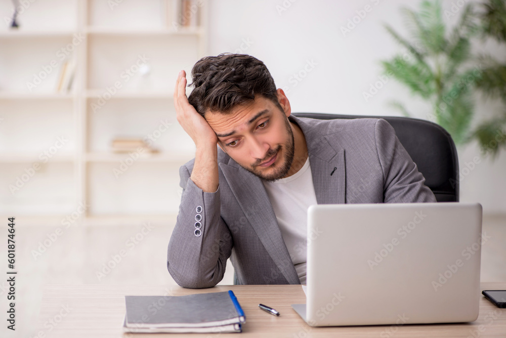 Young male employee working in the office Young male employee working in the office