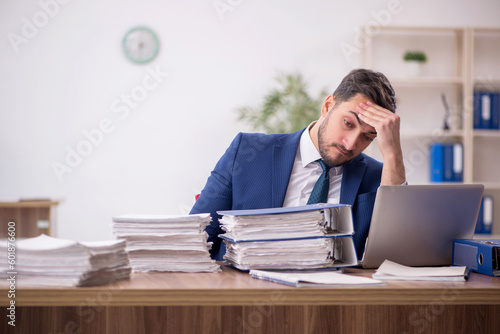 Young male employee and too much work in the office