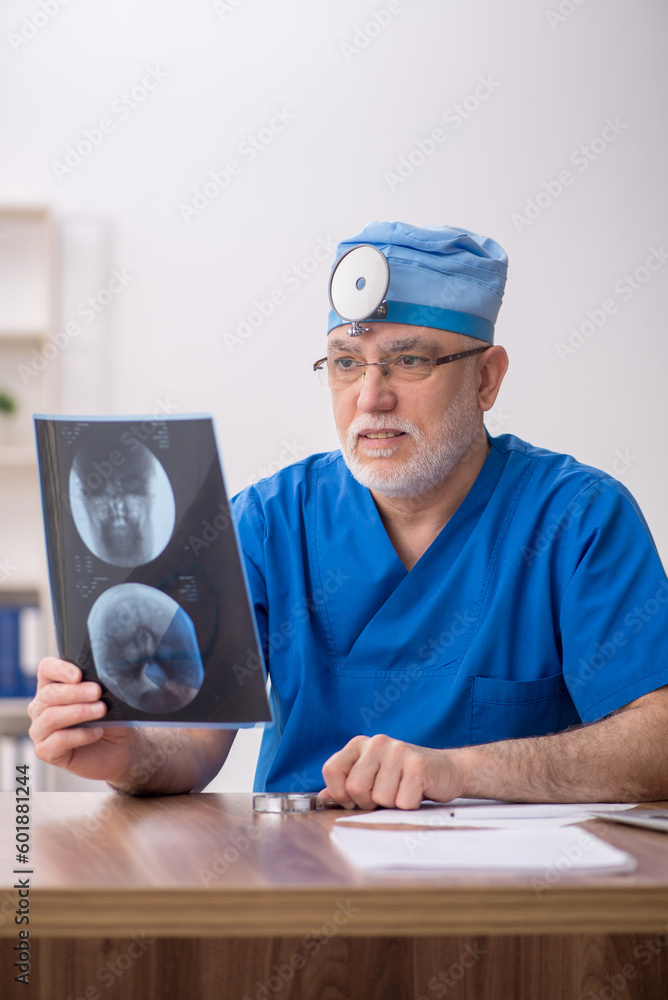 Old male doctor otologist working in the clinic Old male doctor otologist working in the clinic