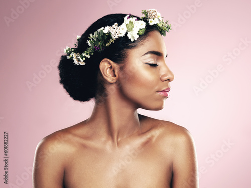 Woman, flowers and hair crown for beauty in studio, pink background and natural skincare glow. African face, female model and floral headband of plants, sustainable cosmetics and eco friendly makeup