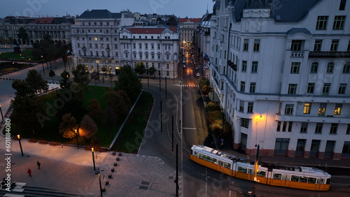Aerial view of Typical Budapest Tram passing through city neighbourhood during blue hour, Aerial tracking follow shot wide angle, Hungary