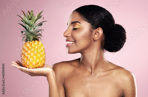Woman, pineapple and smile for beauty in studio, pink background and healthy vitamin c cosmetics. Happy african model, tropical fruits and nutrition for natural skincare, organic benefits and detox
