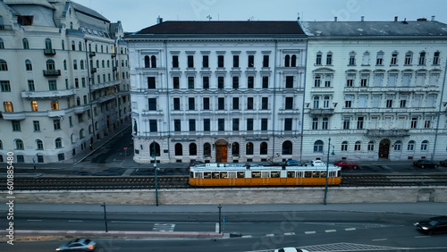 Aerial view of Typical Budapest Tram passing through city neighbourhood during blue hour, Aerial tracking follow shot wide angle, Hungary