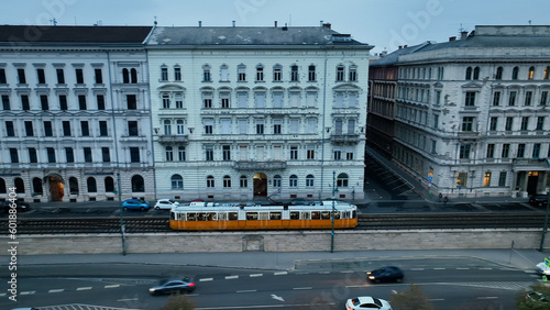Aerial view of Typical Budapest Tram passing through city neighbourhood during blue hour, Aerial tracking follow shot wide angle, Hungary