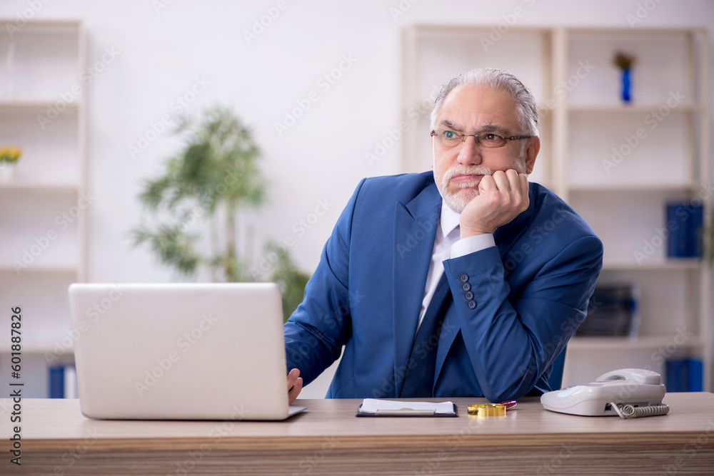 Old male boss working at workplace Old male boss working at workplace
