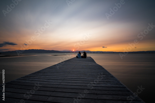 Pareja de enamorados disfrutando de la puesta de sol en la playa del Trabucador, en el Delta del Ebro.
