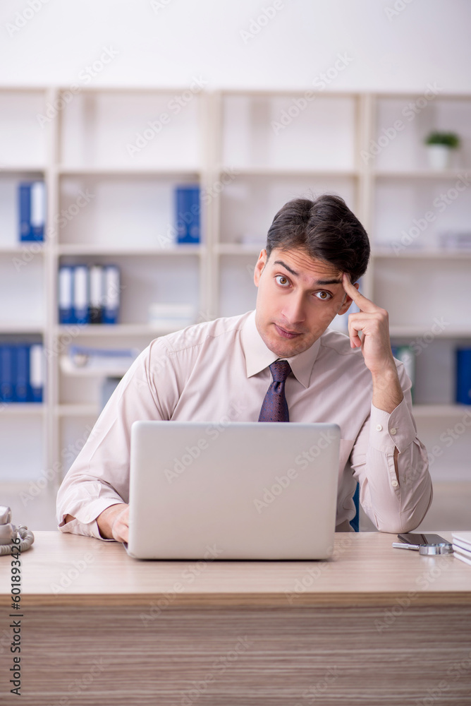 Young male employee working in the office Young male employee working in the office