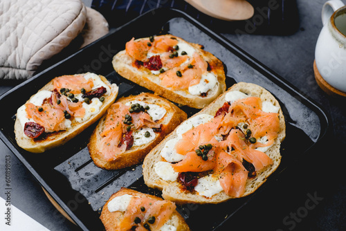 Smoked salmon toasted on sourdough with cheese and sun-dried tomato. Healthy eating, appetizer food, and bread concept. Cooking and gourmet concept
